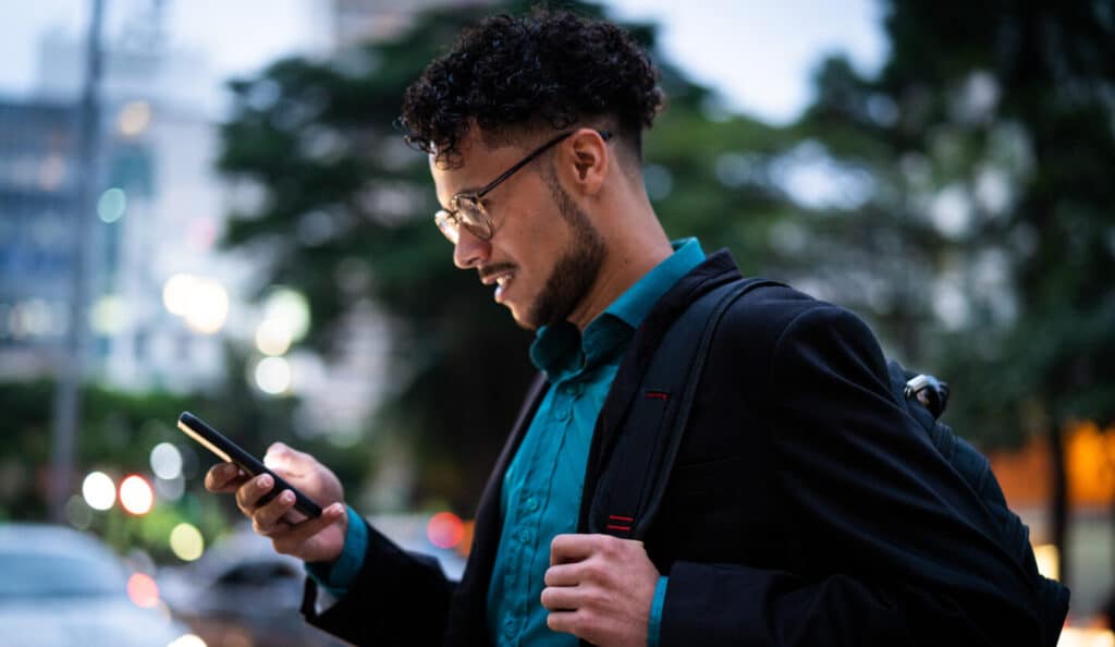 man looking at phone paying medical bill